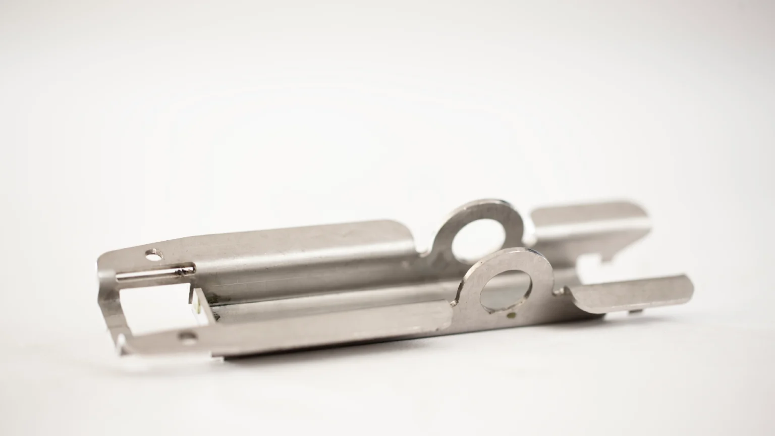 Möbelscharnier mit Entlastungsschnitten für die Biegebearbeitung